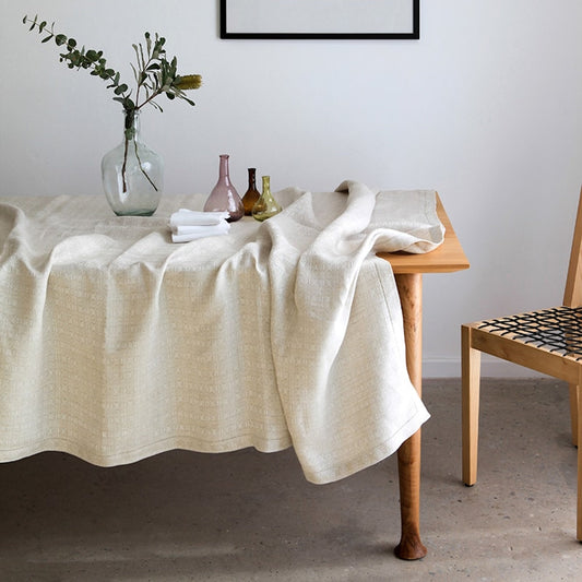 Natural linen tablecloth with woven cloverleaf pattern, dining table